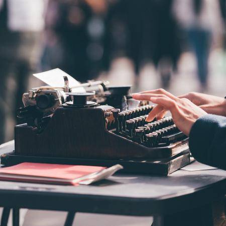 Hand typing on a typewriter