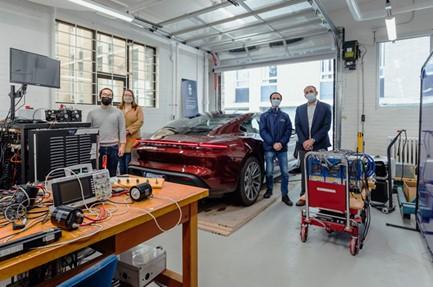 [Professor Olivier Trescases (far right) stands in the University of Toronto Electric Vehicle Research Centre with (left to right) PhD Candidate, Zhe Gong; Wendy Baker, Associate Director Business Development, School of Continuing Studies; and Nick Cusimano, Research Associate. Trescases will teach a course on electric vehicles for Porsche Centre employees. (Photo: Porsche Canada)]